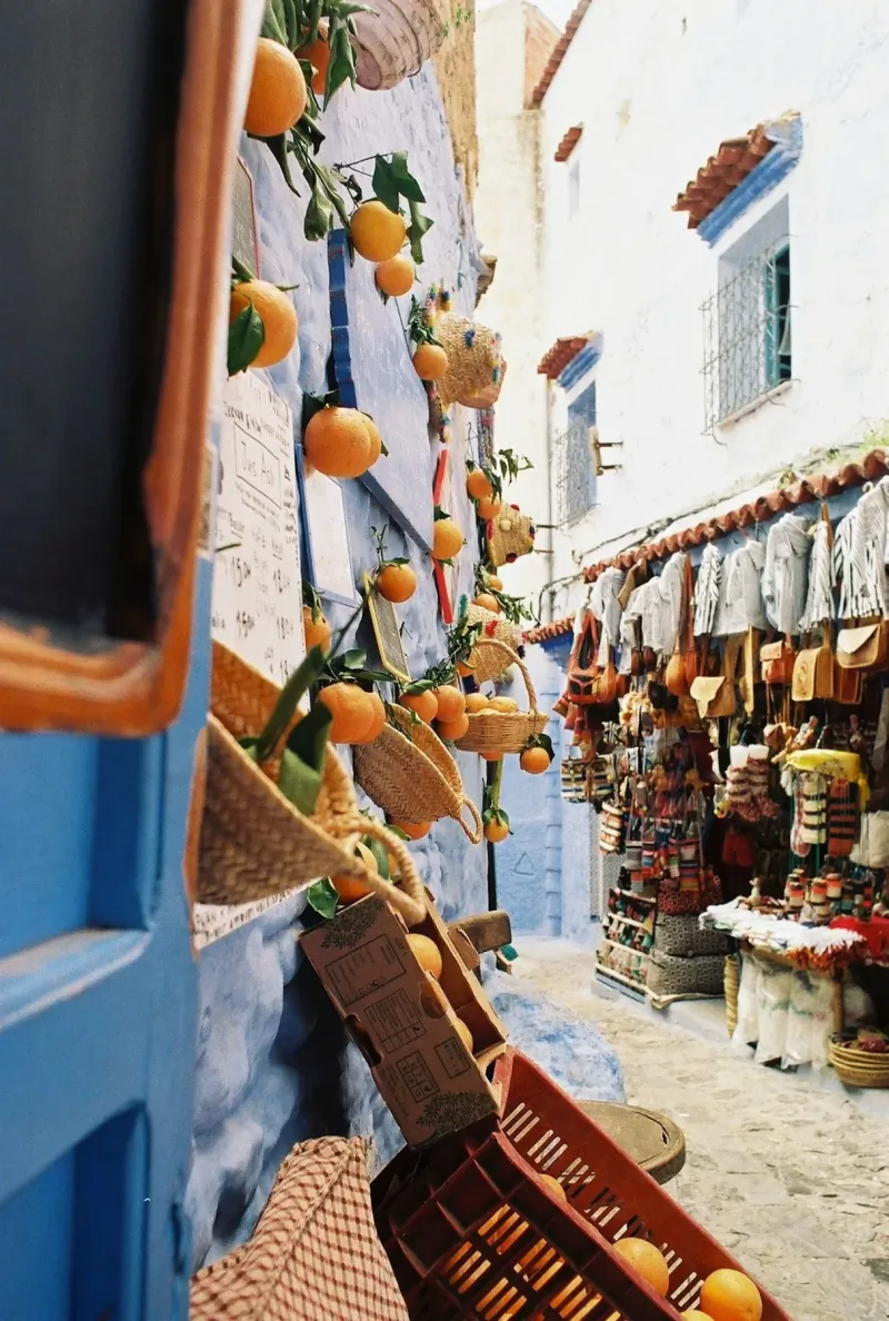 Colorful market lane decorated with oranges in Chefchaouen