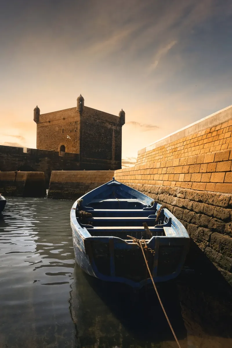 Blue fishing boat beside the historic Essaouira ramparts